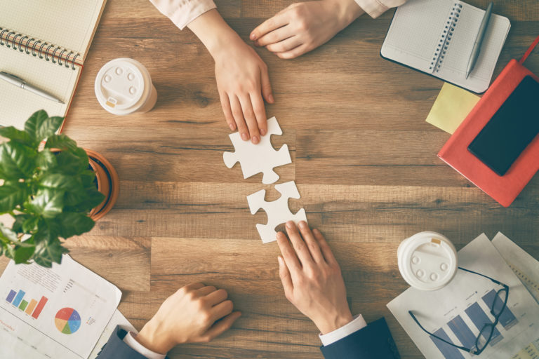 Business man and woman put puzzle pieces together.