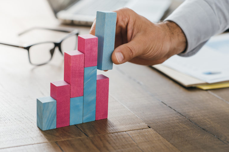Executive stacks blocks showing upward growth on block graph