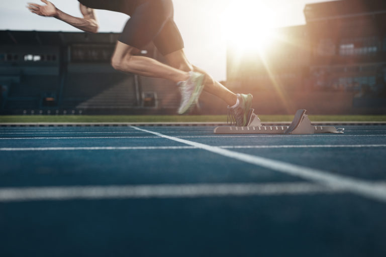 A runner is running quickly on the track